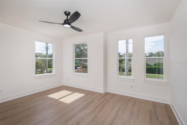 spare room featuring ceiling fan, a wealth of natural light, and light hardwood / wood-style flooring