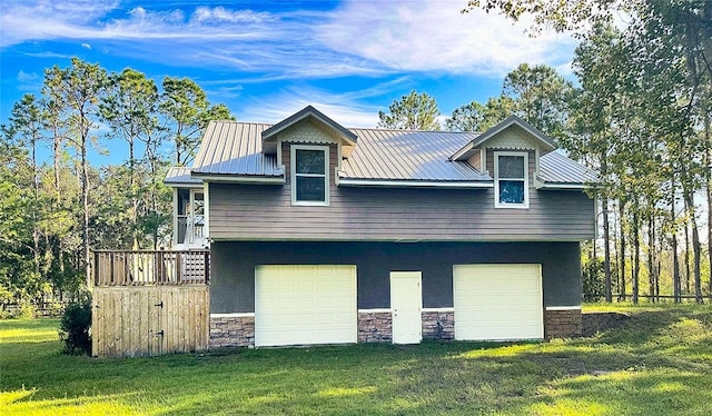 view of home's exterior with stone siding, an attached garage, a yard, and metal roof