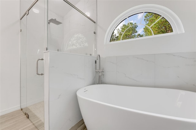 bathroom featuring separate shower and tub