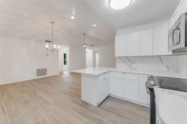 kitchen featuring white cabinetry, decorative backsplash, stainless steel appliances, and kitchen peninsula