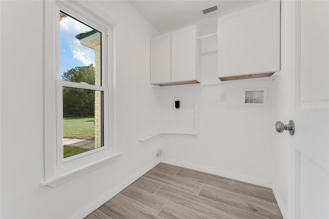 washroom with cabinets, washer hookup, and hookup for an electric dryer