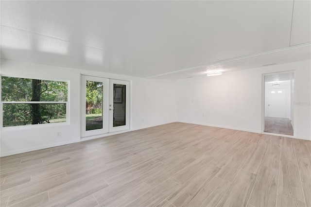 spare room with french doors and light wood-type flooring