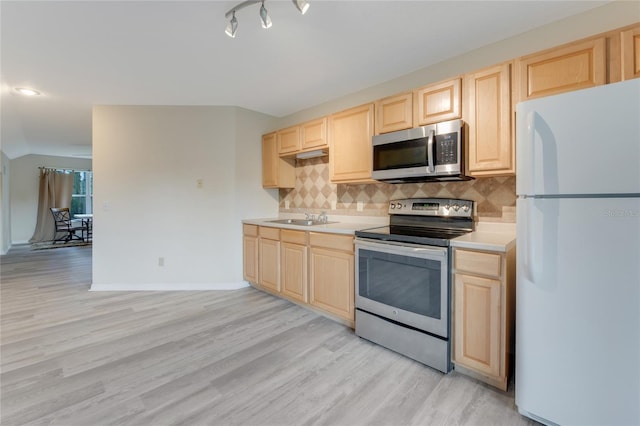 kitchen with light brown cabinetry, sink, decorative backsplash, and appliances with stainless steel finishes