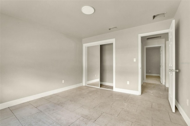 unfurnished bedroom with light tile patterned flooring and a closet