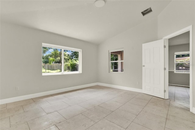 unfurnished room featuring vaulted ceiling and light tile patterned floors