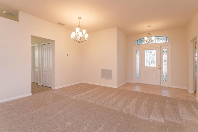 carpeted foyer featuring a notable chandelier