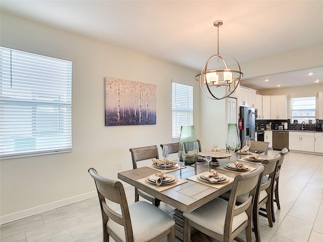 dining room with sink, a chandelier, and light tile patterned floors