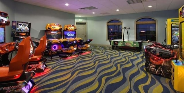 rec room with carpet floors and a paneled ceiling