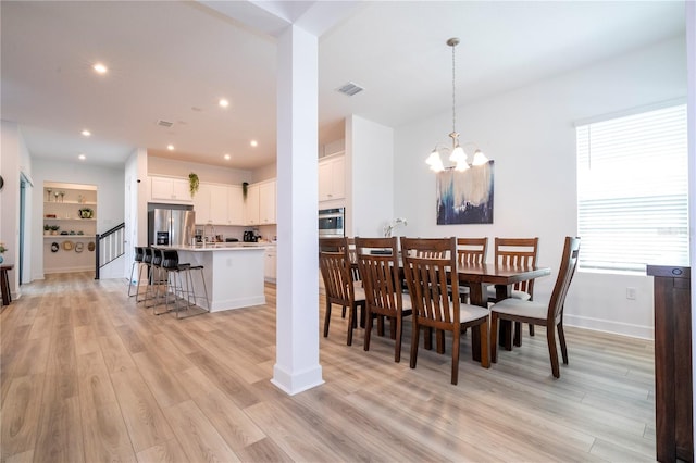 dining space with a notable chandelier and light hardwood / wood-style flooring