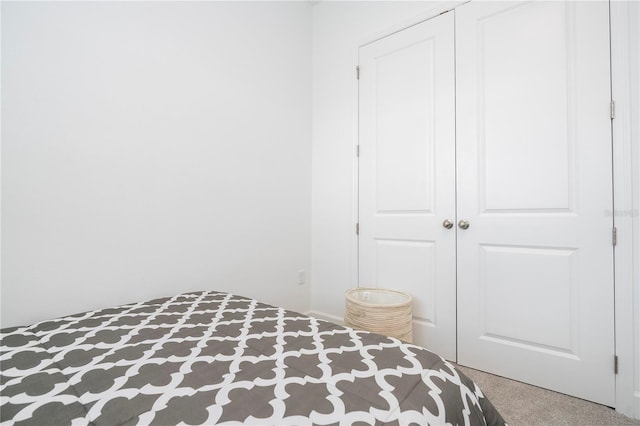 unfurnished bedroom with light carpet and a closet