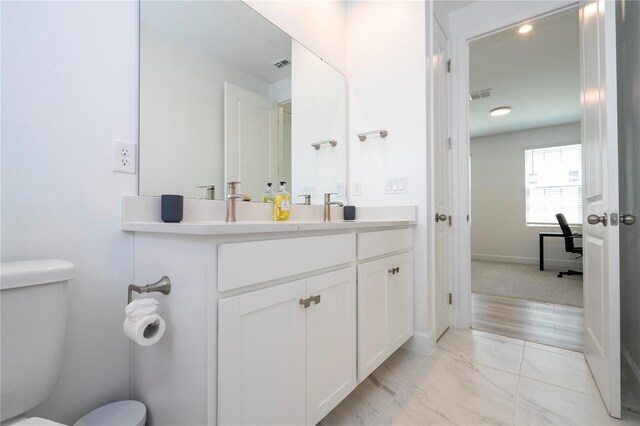 bathroom with vanity, toilet, and wood-type flooring