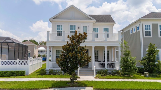 neoclassical / greek revival house with a front lawn, covered porch, and a balcony