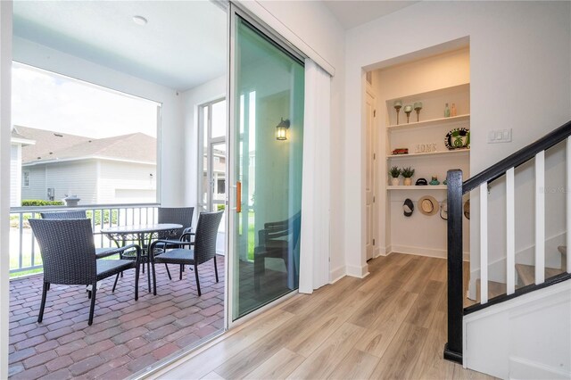 doorway featuring built in features and light hardwood / wood-style floors