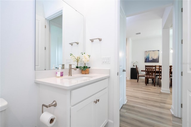 bathroom featuring toilet, hardwood / wood-style flooring, and vanity