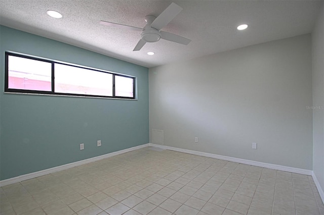 empty room featuring ceiling fan, light tile patterned flooring, and a textured ceiling