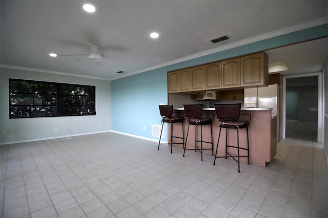 kitchen featuring crown molding, white appliances, a breakfast bar area, and ceiling fan