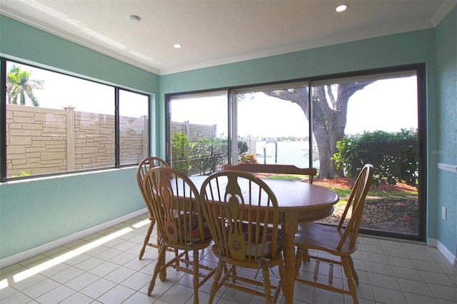 dining space featuring tile patterned flooring, ornamental molding, a water view, and a textured ceiling