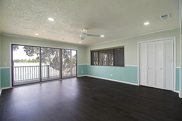 unfurnished room with a textured ceiling, dark wood-type flooring, and ceiling fan