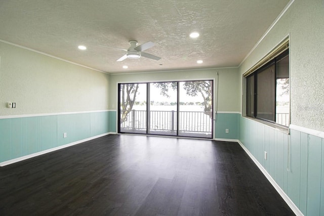 spare room featuring ceiling fan, dark hardwood / wood-style flooring, crown molding, and a textured ceiling