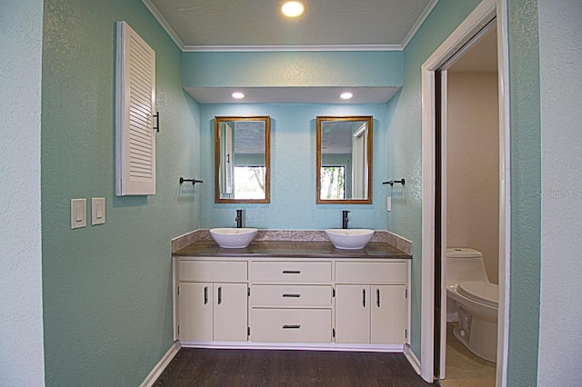 bathroom with crown molding, toilet, hardwood / wood-style floors, and double vanity