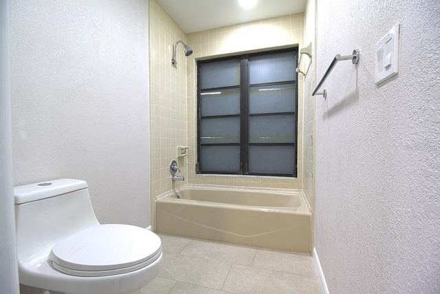 bathroom featuring toilet, tiled shower / bath combo, and tile patterned floors