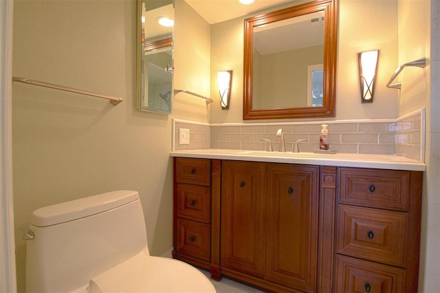 bathroom featuring vanity, toilet, and backsplash