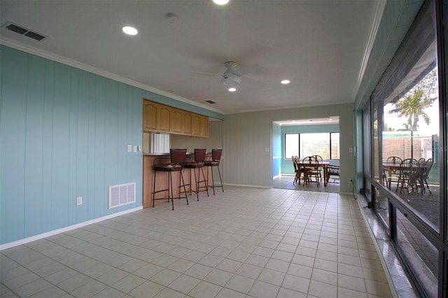 tiled living room featuring crown molding and ceiling fan