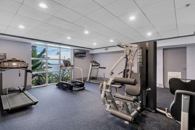 workout room featuring floor to ceiling windows and a paneled ceiling