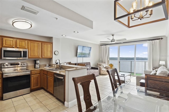 kitchen with sink, stainless steel appliances, kitchen peninsula, pendant lighting, and light tile patterned flooring