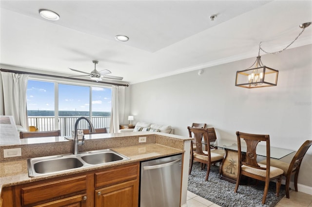 kitchen with sink, hanging light fixtures, a water view, ceiling fan with notable chandelier, and stainless steel dishwasher