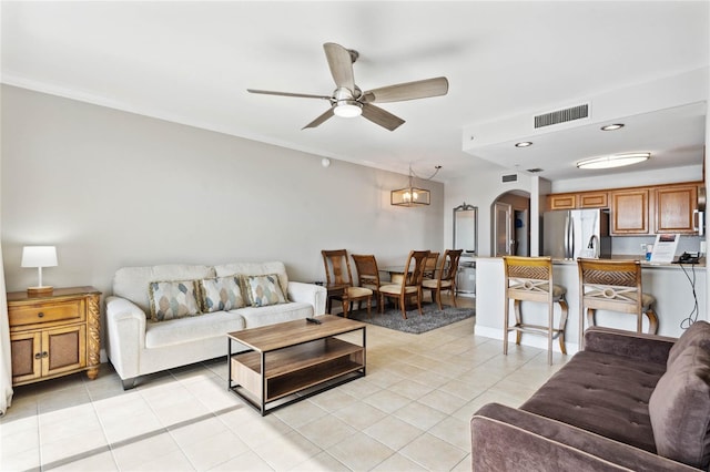 tiled living room featuring crown molding and ceiling fan