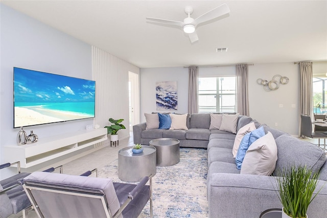 living room featuring ceiling fan, light tile patterned flooring, and a wealth of natural light