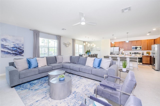 living area featuring ceiling fan with notable chandelier, visible vents, and recessed lighting