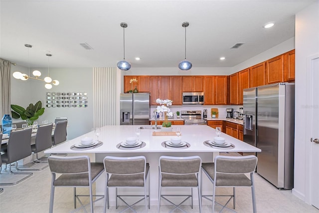 kitchen with a sink, visible vents, stainless steel appliances, and light countertops