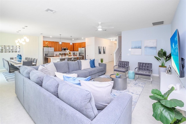 living area featuring recessed lighting, visible vents, baseboards, and ceiling fan with notable chandelier