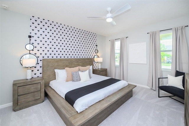 bedroom featuring a ceiling fan, light colored carpet, and baseboards