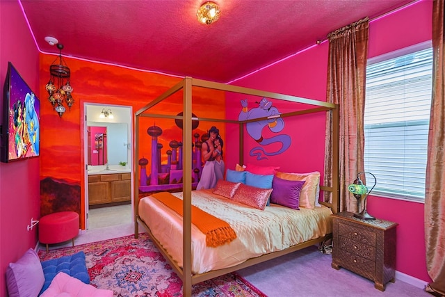 bedroom with a textured ceiling, multiple windows, a sink, and ensuite bath