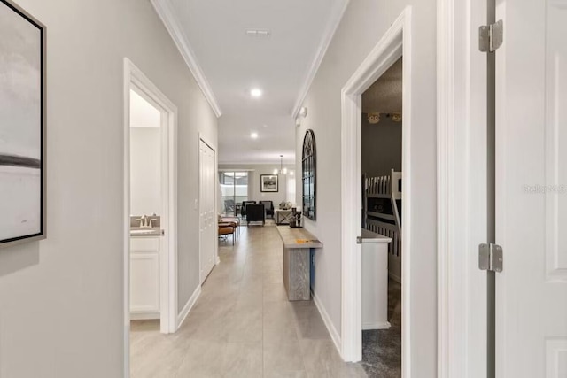 corridor featuring ornamental molding, light tile patterned floors, and sink