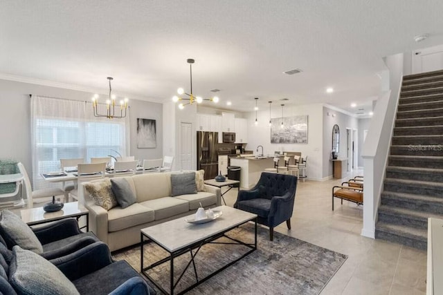 living room featuring light tile patterned floors, sink, an inviting chandelier, and crown molding