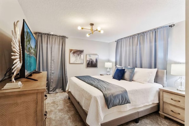 carpeted bedroom with a textured ceiling and a chandelier