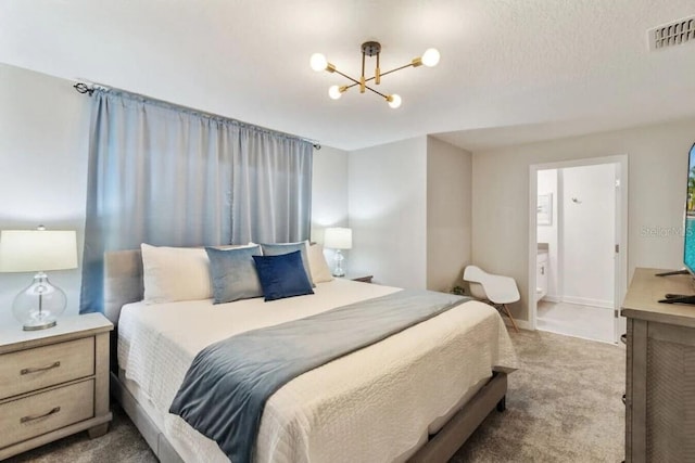 carpeted bedroom with ensuite bath and a notable chandelier