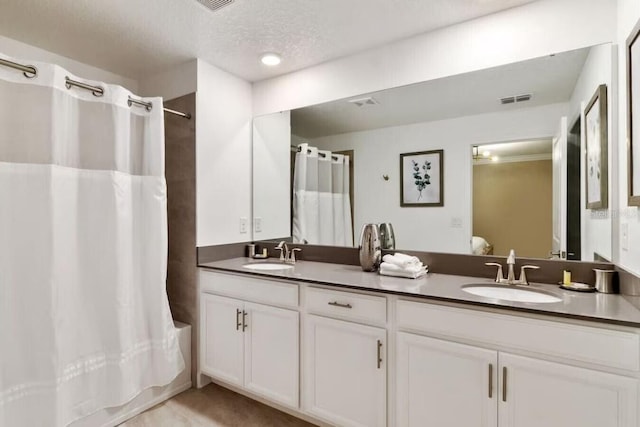 bathroom featuring a textured ceiling, double vanity, and shower / bath combo