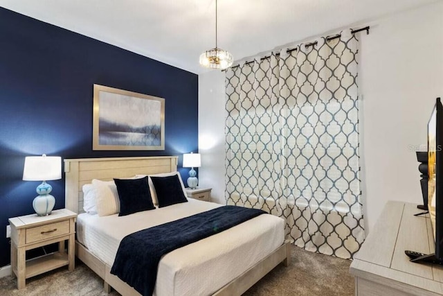 bedroom featuring a notable chandelier and carpet floors