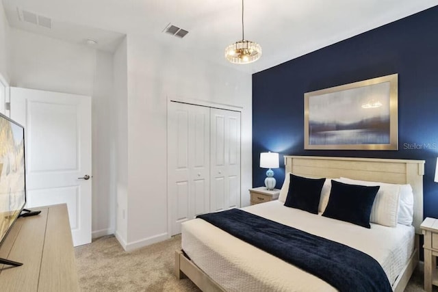 bedroom with light carpet, a closet, and a chandelier