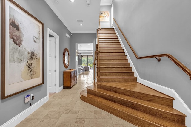 stairs with crown molding and tile patterned floors