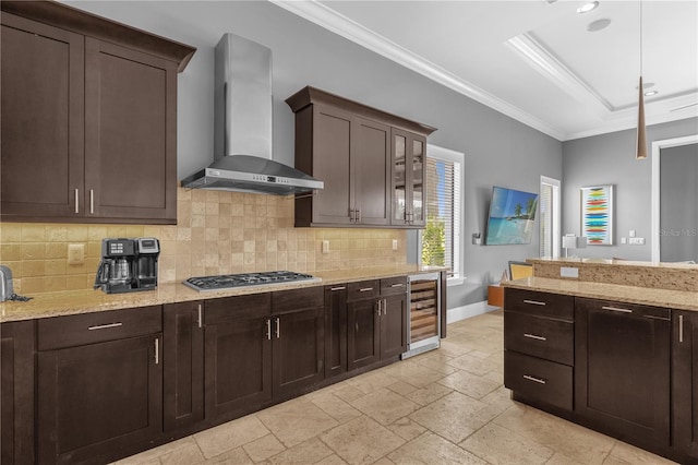 kitchen featuring light stone counters, wall chimney range hood, stainless steel gas cooktop, and wine cooler