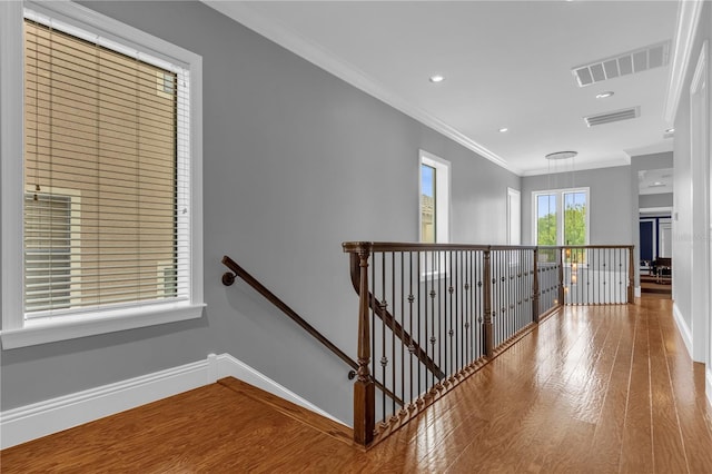 corridor featuring wood-type flooring and ornamental molding