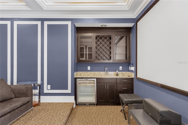 bar featuring sink, wine cooler, light colored carpet, crown molding, and dark brown cabinets