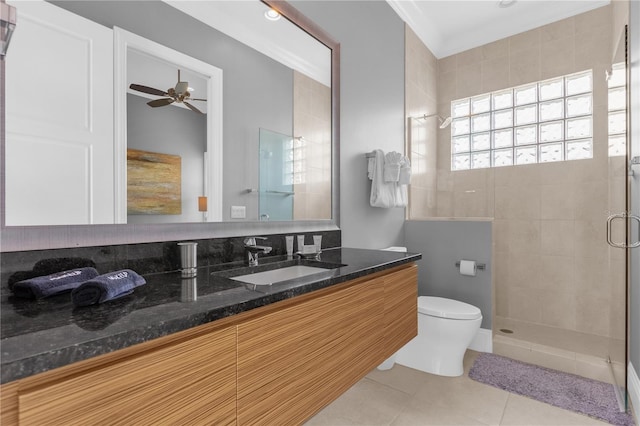 bathroom with a shower with shower door, vanity, ceiling fan, toilet, and tile patterned floors