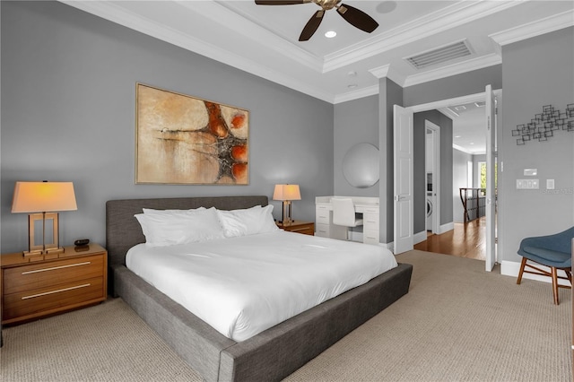 bedroom with crown molding, light carpet, ceiling fan, and a tray ceiling